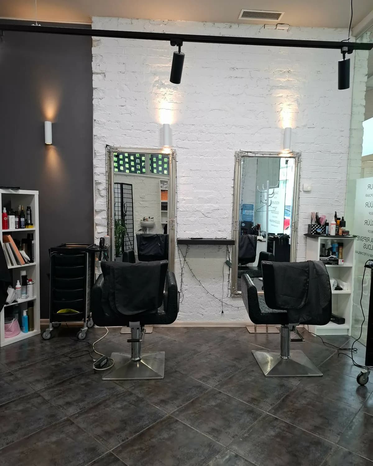 Colorist Beauty Salon juuksurisaal: peeglid valgel telliskiviseinal ja mustad toolid